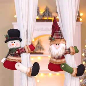 Detail of Santa and Snowman plush curtain buckles on white drapes with festive fireplace