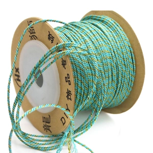 Close-up of cyan and gold hand-twisted 1mm metallic cord on a vintage paper spool