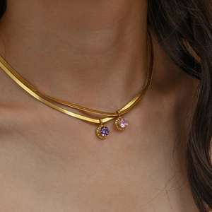 Close-up of double-layer gold necklace featuring purple and pink zircon pendants