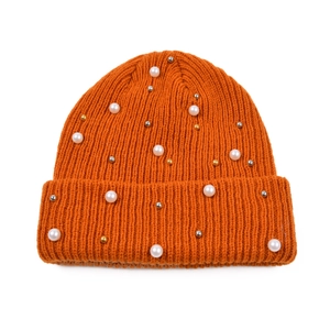 Dettaglio del berretto in maglia arancione con perle bianche e perline metalliche