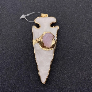 Detailed view of a white resin cone pendant with gold plating and pink crystal inlay