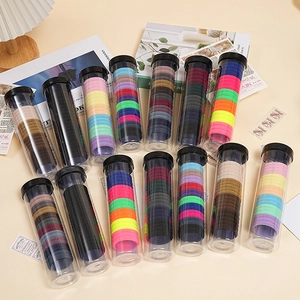 Set of 12 jars containing colorful elastic hair ties in various vibrant candy colors