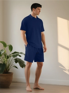 Dettaglio ravvicinato del tessuto testurizzato blu scuro del set polo e maglia fine
