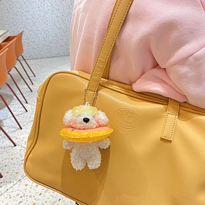 Ciondolo cane di peluche con occhiali da sole e salvagente su borsa gialla