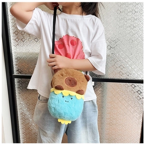 Detail of a cute brown plush Capybara bag with blue strawberry accent and thin strap