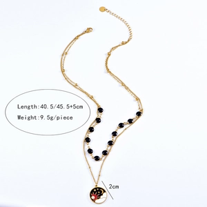 Détails du collier double rang avec perles noires et pendentif soleil lune ciselé