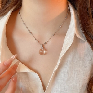 Close-up of sparkling crystal pendant necklace with delicate silver chain on model