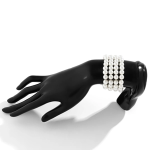 Detailed view of layered faux pearl bracelet on black mannequin hand display