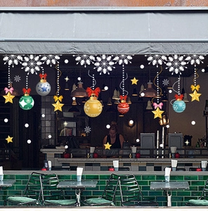 Detail of festive Christmas window decals featuring white snowflakes and colorful baubles