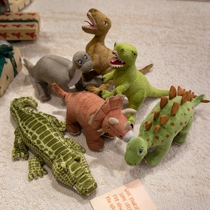 Set of 6 cartoon dinosaur plush toys in earthy tones on a soft carpet for kids
