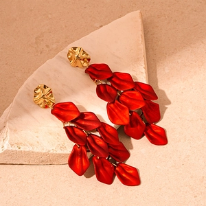 Detail view of elegant red acrylic petal tassel earrings with textured gold studs