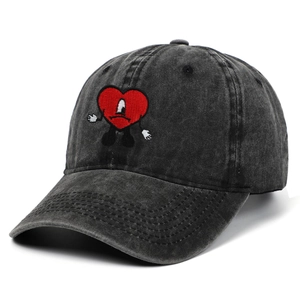 Dettaglio del ricamo a cuore rosso sul cappellino in denim grigio scuro lavato