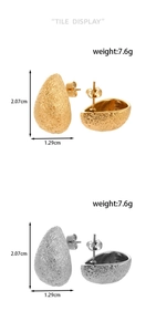 Detailed view of teardrop earrings with matte texture showing gold and silver finishes