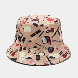 Vue détaillée du chapeau de soleil beige avec imprimés cosmétiques et motifs de parfum