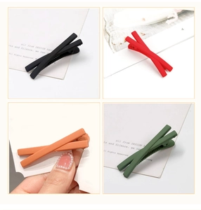 Detail view of four matte cross hair clips in black, red, orange, and green colors