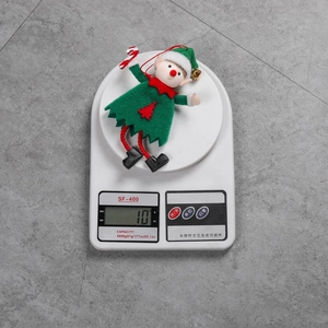Detailed view of 10g lightweight Christmas elf ornament with candy cane on a scale