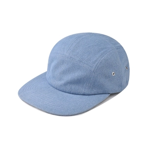 Detail of light blue denim 5-panel flat brim cap with metallic eyelets and neat stitching