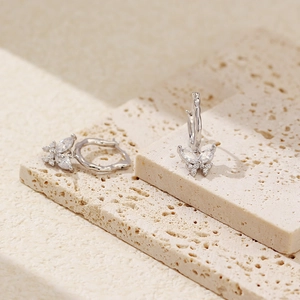 Detailaufnahme von S925 Silber Schmetterlings-Ohrringen mit Zirkon auf hellen Steinen