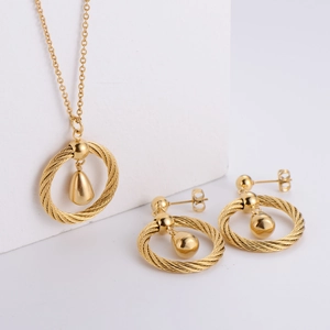Three-piece titanium steel jewelry set with teardrop pendants on white geometric display