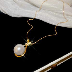 Makro-Detail einer weißen Perle mit Zirkon-Inlay an einer goldenen Halskette für Damen