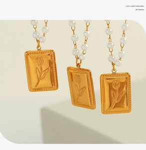Dettaglio del ciondolo rettangolare a tulipano dorato con collana di perle bianche