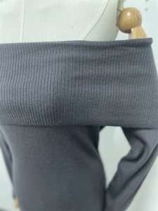 Detail of grey off-the-shoulder knitted dress showing vertical ribbed texture and neckline