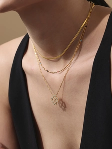 Detail of layered gold clover necklace with sparkling cubic zirconia on a model