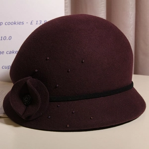 Dettaglio cappello cloche in lana bordeaux con fiori fatti a mano e perline applicate