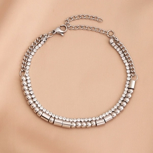Detail of silver layered bracelet with rhinestones and beads on beige satin fabric