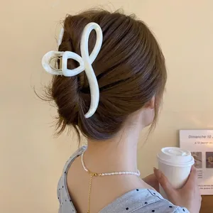 Minimalist creamy white marble hair claw clip for women in a chic twisted design