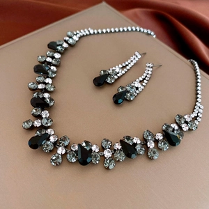 Detailed view of elegant necklace and earrings set with black and grey rhinestones