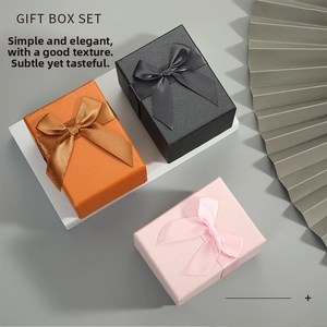 Three-piece gift box set in orange, black, and pink with satin bow and textured surface