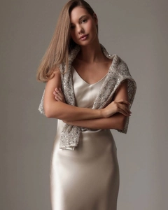 Detail eines champagnerfarbenen Satin-Kleids mit einem feinen Pailletten-Strickschal