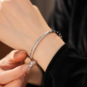 Close-up of silver segment scale bracelet with snake bone design on a model's wrist