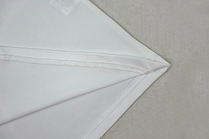 Close-up of white knit dress seam showing high-quality overlock stitching detail
