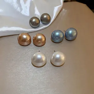 Set of four pairs of large pearl stud earrings in white, gold, grey and blue colors