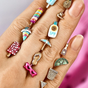 Macro shot of summer-themed fruit and beach earrings with colorful rhinestones
