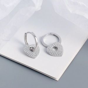 Macro shot of S925 silver heart hoop earrings with pavé set shimmering white zircons