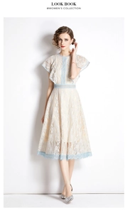 Detail of white lace dress featuring blue scalloped trim and elegant butterfly sleeves