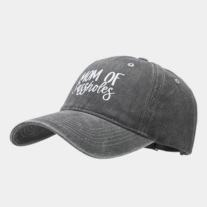 Close-up of washed cotton texture and white embroidered text on dark grey baseball cap
