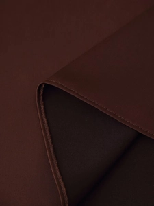 Macro shot of dark brown satin fabric with precise edge stitching and textile texture
