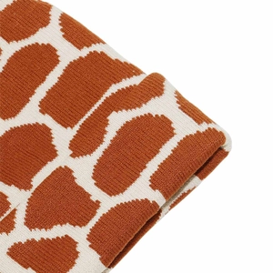 Macro detail of giraffe pattern knit texture on caramel and beige winter beanie