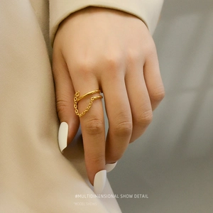 Double-layered 18K gold plated titanium ring with tassel chain on a model's finger