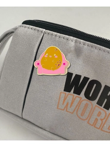 Gros plan d'un badge émaillé patate mignonne sur un sac en toile grise décoratif
