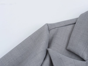 Gros plan d'un blazer gris clair montrant le revers et les détails de couture fins