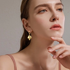 Vintage mushroom dangle earrings in 18k gold plated stainless steel on a model