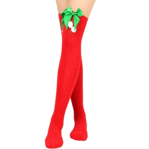 Detail of red Christmas over-the-knee socks with green satin bow and white plush pom-poms