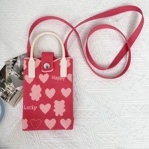 Detailed knit texture of hot pink crossbody phone bag with cute heart and bear patterns