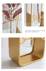 Detail of gold geometric iron vase with glass tube and Love metal lettering script