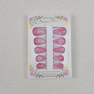 Detailed view of long almond press-on nails with 3D floral and butterfly designs